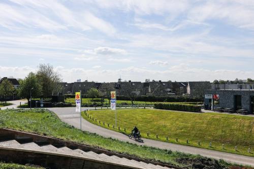 a person riding a bike down a road at Strand Appartementen Wemeldinge in Wemeldinge