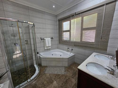 a bathroom with a tub and a shower and a sink at Leopard Corner Lodge in St Lucia
