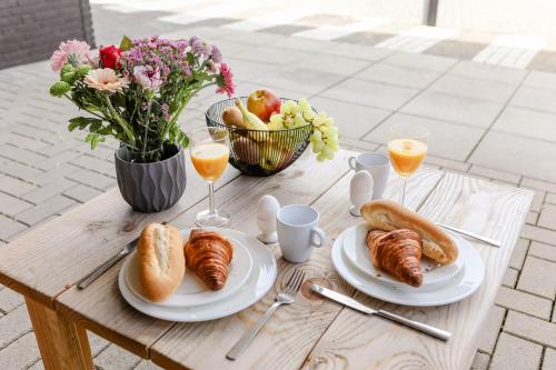 a table with plates of food and a bowl of fruit at Strand Appartementen Wemeldinge in Wemeldinge