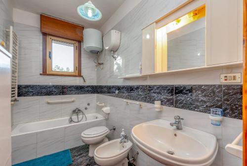 een badkamer met een wastafel, een toilet en een bad bij Casa vacanza zia candida in Casalabate