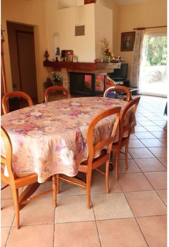 une table de salle à manger avec des chaises et une table avec une nappe fleurie dans l'établissement Cœur de Millas terrasse, jardin et parking privé, à Millas