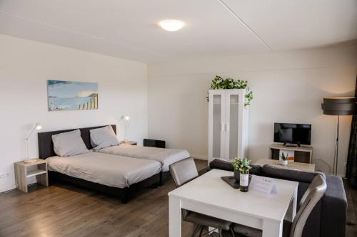 ウェーメルディンゲにあるStrand Appartementen Wemeldinge I Bella Zeelandiaのベッドルーム1室(ベッド1台付)、リビングルームが備わります。