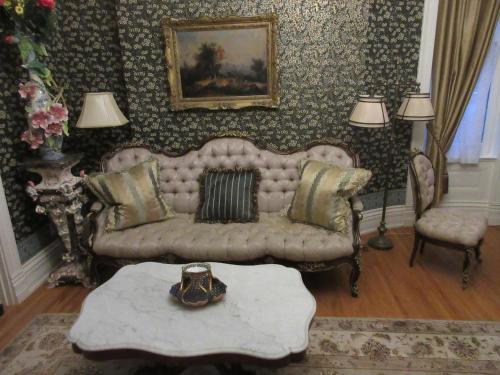 - un salon avec un canapé et une table dans l'établissement Johnstone Mansion, à Keokuk