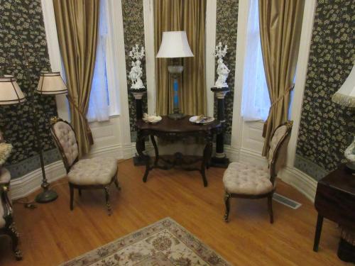 une chambre avec une table, deux chaises et une lampe dans l'établissement Johnstone Mansion, à Keokuk