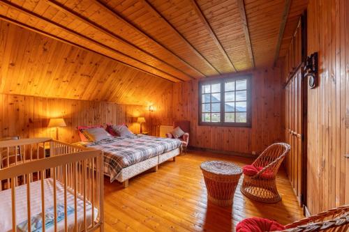 a bedroom with a bed in a wooden room at Chalet des Ormes - Maison pour 12 vue montage in Les Combes