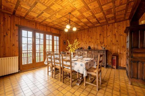 d'une salle à manger avec une table et des murs en bois. dans l'établissement Chalet des Ormes - Maison pour 12 vue montage, à Les Combes
