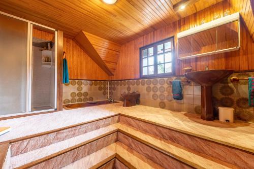 a large bathroom with a sink and a wooden ceiling at Chalet des Ormes - Maison pour 12 vue montage in Les Combes