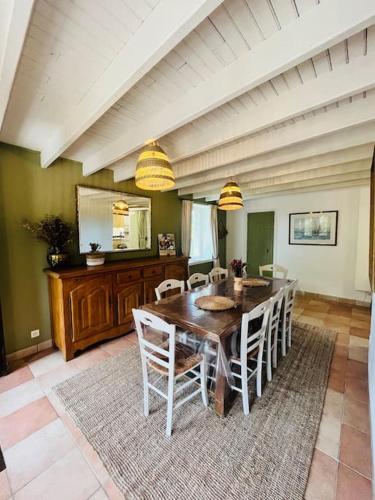 une salle à manger avec une table et des chaises en bois dans l'établissement La campagne et la mer, à Tourville-sur-Sienne