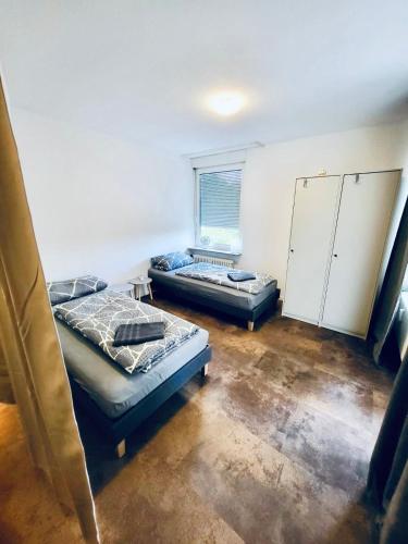 a room with two beds and a window at nJoy! Comfort & Spacious - Balkon - gratis WLAN - perfekt für Work & Travel in Bietigheim-Bissingen