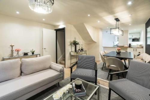 een woonkamer met een bank en een tafel bij BuckinghamPalace-SuperLuxury-Victoria-Westminster-Belgravia-StJamesPark in Londen