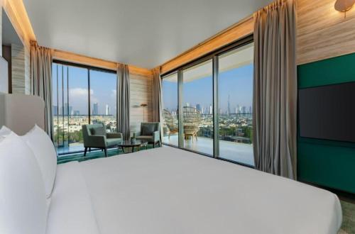 ein Schlafzimmer mit einem großen Bett und großen Fenstern in der Unterkunft Hyatt Centric Jumeirah Dubai - Executive Room - UAE in Dubai