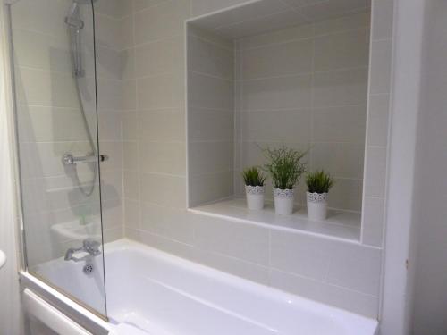 a bathroom with a tub and two potted plants at Mia's Place Three Apartments in One in Chester