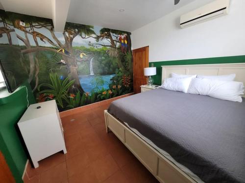 a bedroom with a bed with a painting on the wall at Luxury Villa with Separate Guest house and 360view in Quepos