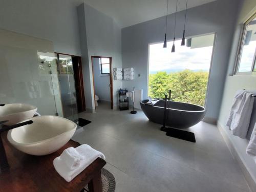 a bathroom with a large tub and a large window at Luxury Villa with Separate Guest house and 360view in Quepos