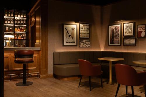 a bar with a couch and chairs in a room at Hotel Indigo - Dundee by IHG in Dundee