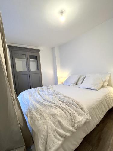 a bedroom with a bed with white sheets at Charmant 2 Pièces coeur de Bastia in Bastia