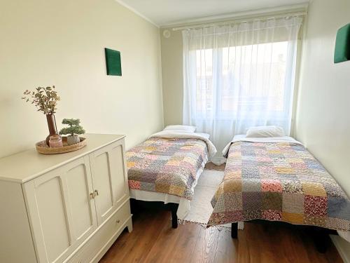 two beds in a room with a window at Kuressaare Pikk Apartment in Kuressaare