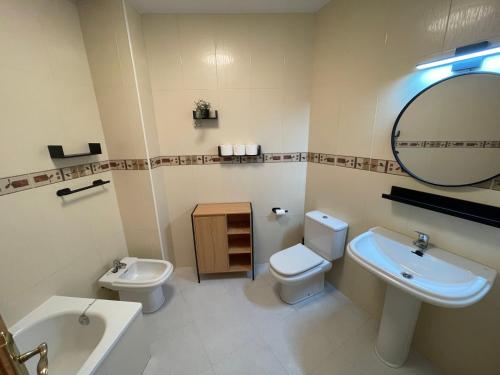 uma casa de banho com um lavatório, um WC e um espelho. em Apartamento Plaza de la Anunciación em Bélmez