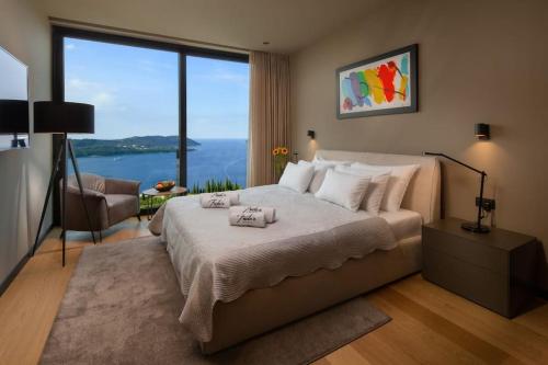 a bedroom with a large bed with a large window at Frida's Villa in Dubrovnik
