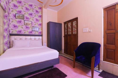 a bedroom with a bed and a blue chair at FabHotel Poorv Sight in Varanasi