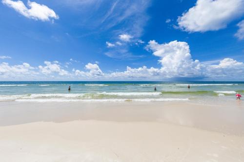 un grupo de personas de pie en el agua en una playa en Plantation Dunes 5316 Shore to Please, en Gulf Shores