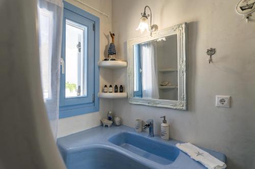 a blue tub in a bathroom with a mirror at Blu Suites and Studios in Adamas