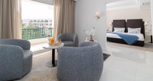 a hotel room with two chairs and a bed at El Mouradi Palace- Couple et Famille uniquement in Port El Kantaoui