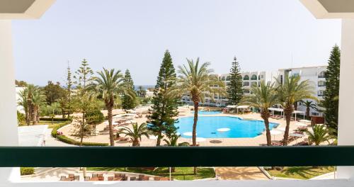 a view of a pool from the balcony of a resort at El Mouradi Palace- Couple et Famille uniquement in Port El Kantaoui