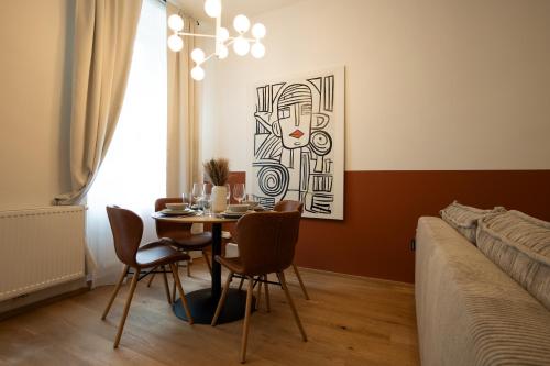 een eetkamer met een tafel en stoelen en een bed bij Bright, modern and central flat with a terrace in Wenen