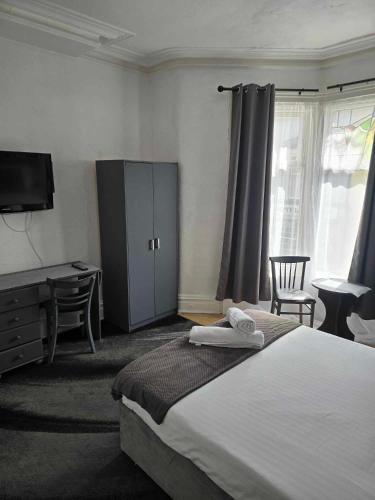 a bedroom with a bed and a desk and a tv at ROSE in Blackpool