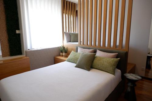a bedroom with a bed with pillows and a window at Porto Family Home by MP - Renovated in Porto