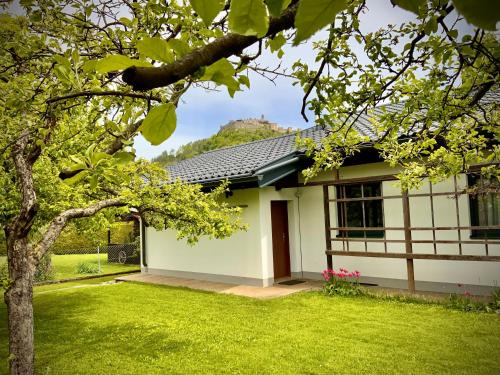 una casa bianca con un prato verde davanti di GARDEN PARADISE - Ferienhaus mit 400m2 Garten - Nähe Ossiacher See a Villach