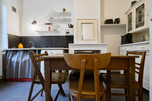 une cuisine avec une table et des chaises en bois dans l'établissement Maisonnette atypique dans le vieux Lille, à Lille