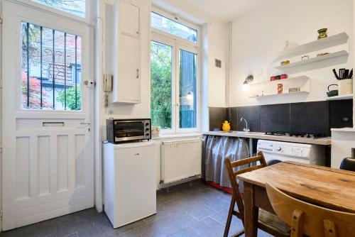 une cuisine avec une table et un réfrigérateur blanc dans l'établissement Maisonnette atypique dans le vieux Lille, à Lille