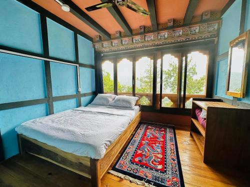 een slaapkamer met een bed in een kamer met ramen bij CheChey Village Homestay in Punākha
