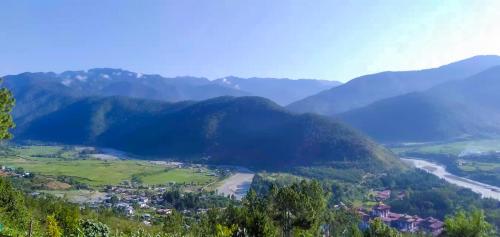 een uitzicht op een vallei met een rivier en bergen bij CheChey Village Homestay in Punākha