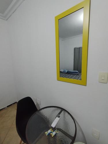 a glass table in a room with a mirror at Hotel Indi Suíte Standard in Ribeirão Preto