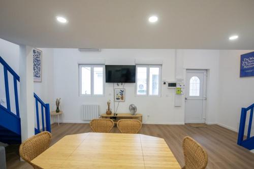 Cette chambre dispose d'une table, de chaises et d'une télévision. dans l'établissement Casa Azul - Belle maisonnette colorée - Garibaldi, à Lyon