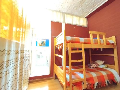 a bedroom with two bunk beds and a window at Hotel Rosim Cotopaxi in Latacunga