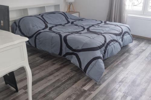 - un lit avec une couette en noir et blanc dans une chambre dans l'établissement 45 m2 au Centre Ville - Les bougies, à Corbeil-Essonnes