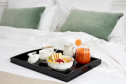 ein Tablett mit Speisen und Getränken auf dem Bett in der Unterkunft 2 Chesham Hotel in London