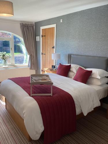 a hotel room with a large bed with red pillows at The Garden Suites at Snape Castle Mews in Bedale