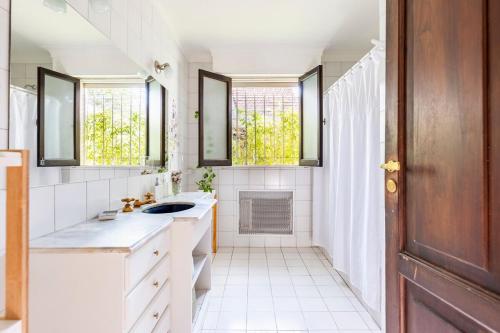 baño con lavabo y 2 ventanas en Casa Noble en Mendoza