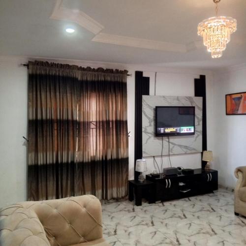 - un salon avec un canapé et une télévision dans l'établissement J Lounge, à Ikorodu
