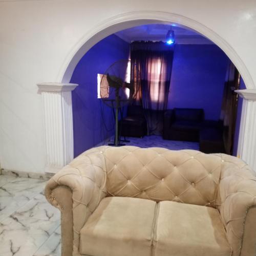 um sofá numa sala de estar com uma parede azul em J Lounge em Ikorodu
