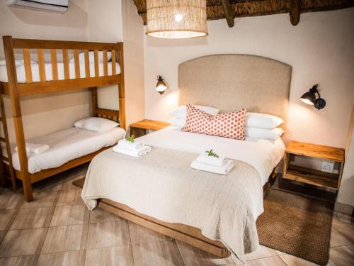 2 Betten in einem Zimmer mit 2 Etagenbetten in der Unterkunft Bona Bona Game Lodge in Wolmaranstad