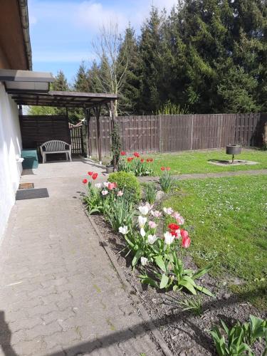 a garden with a bench and flowers in a yard at Ferienwohnung Reepschläger in Papendorf