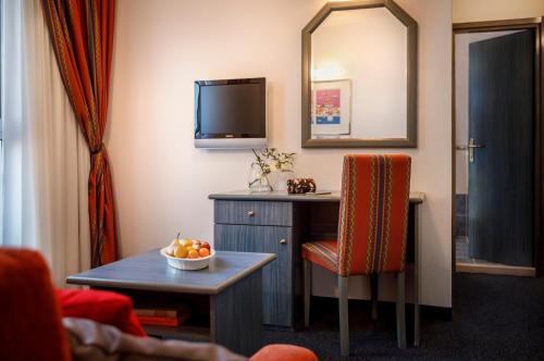 a room with a table and a chair and a mirror at Laguna Maradiso Hotel by Aminess in Novigrad Istria