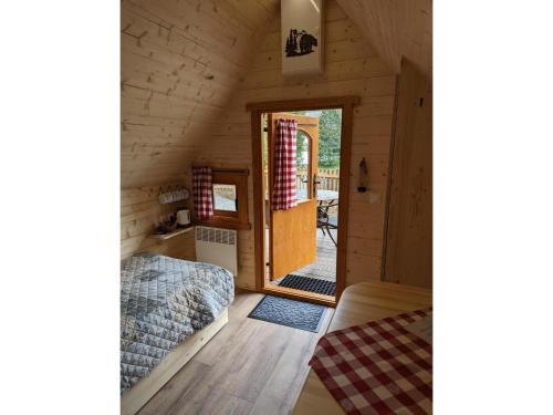um quarto com uma cama e uma porta numa cabina em Klosterweiherhof em Dachsberg im Schwarzwald