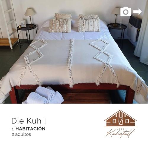 a bedroom with a large bed with white sheets and pillows at Casa Kuhstall in La Cumbrecita
